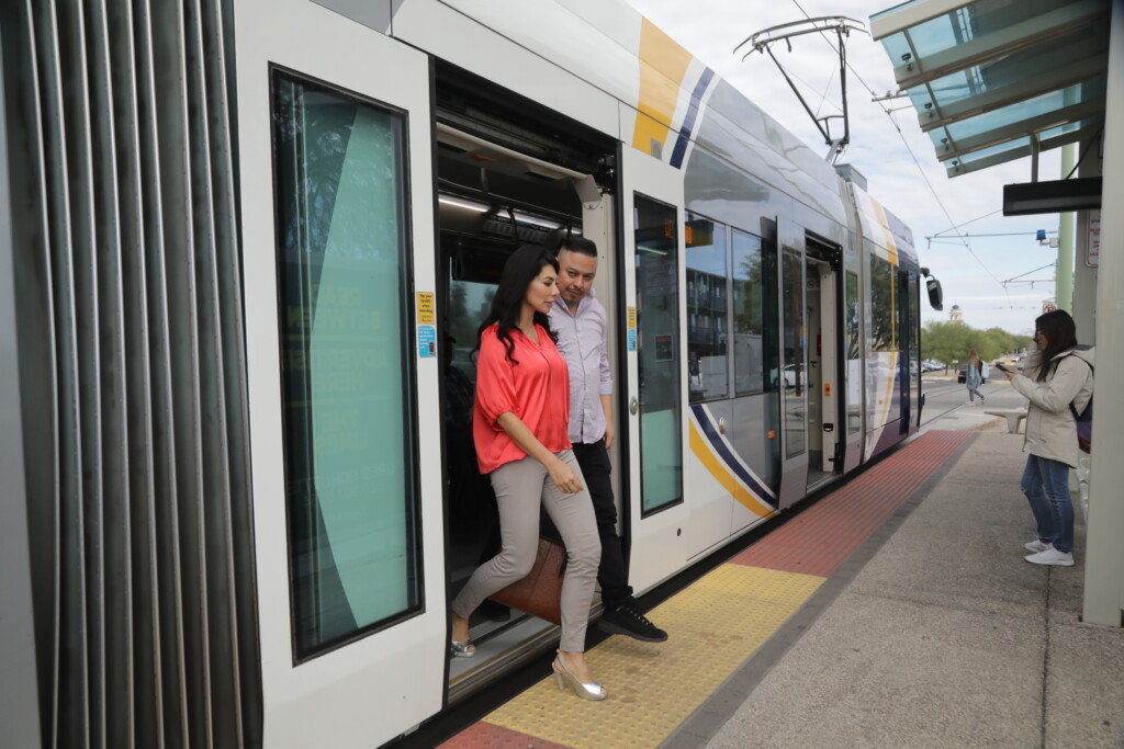couple stepping out of sun link streetcar